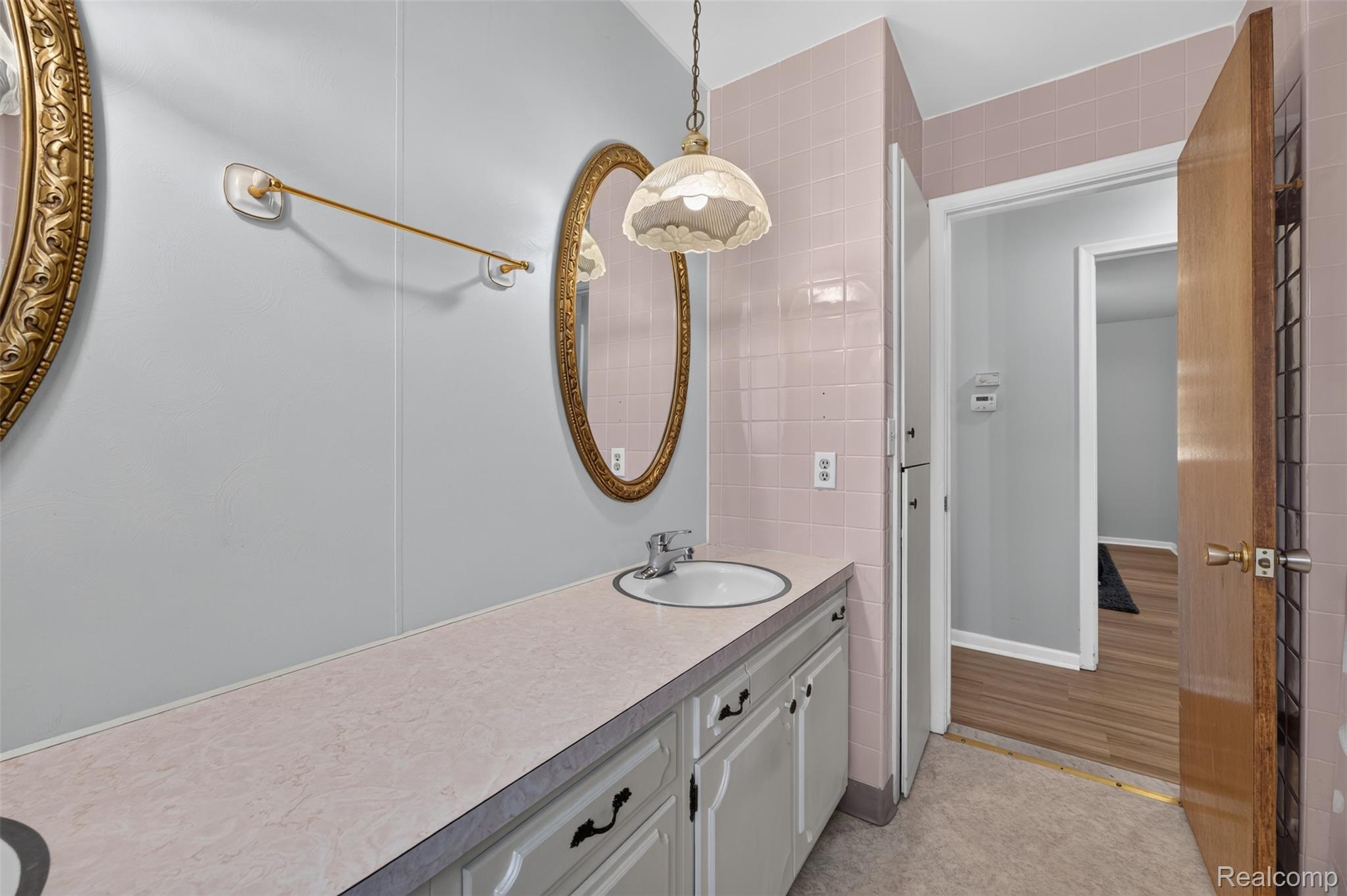 12055 West Pierson Road Flushing, MI 48433 - Photo 37 of 69 Built-in vanity with under-sink cabinetry, integrated basin, and an ornate framed mirror