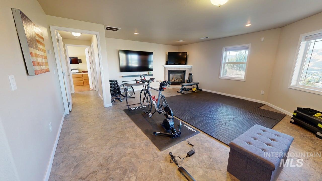 1724 Ridgeview Drive Clarkston, WA 99403 - Photo 36 of 48 Exercise room featuring a tile fireplace, recessed lighting, and light tile patterned flooring