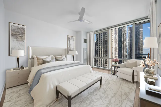 a spacious bedroom with a bed a couch and a large window