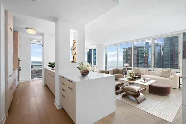 a living room with furniture wooden floor and large windows