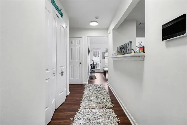 a hallway with white cabinets and wooden floor