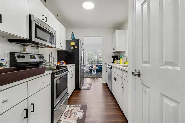 a kitchen with a sink cabinets and wooden floor