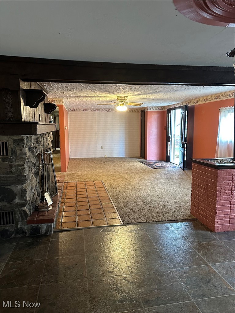 44952 Moose Ridge Road Woodsfield, OH 43793 - Photo 19 of 48 Unfurnished living room with dark carpet, a ceiling fan, and beamed ceiling