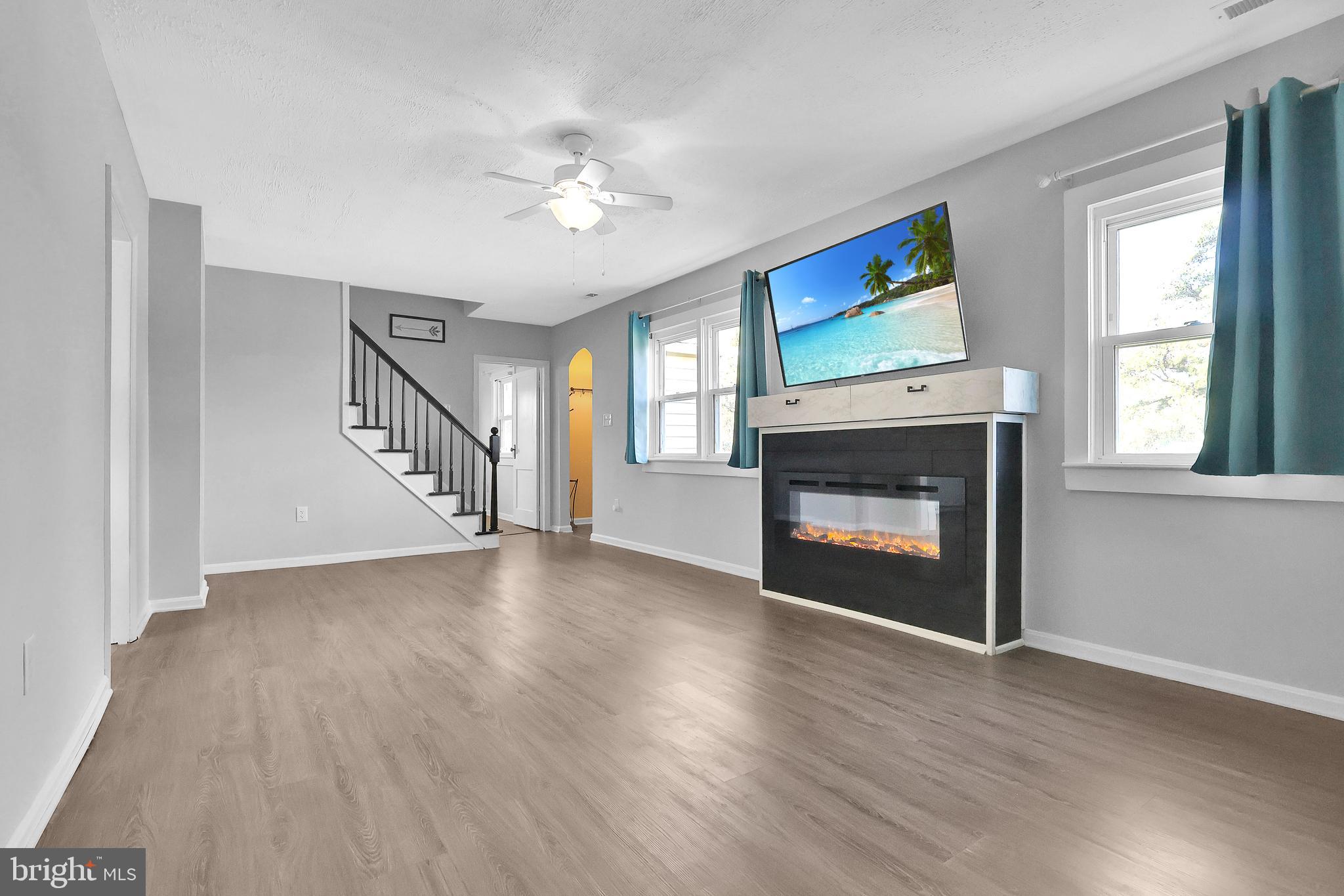 16392 Ball Point Road Piney Point, MD 20674 - Photo 7 of 25 a view of an empty room with wooden floor fireplace and a window