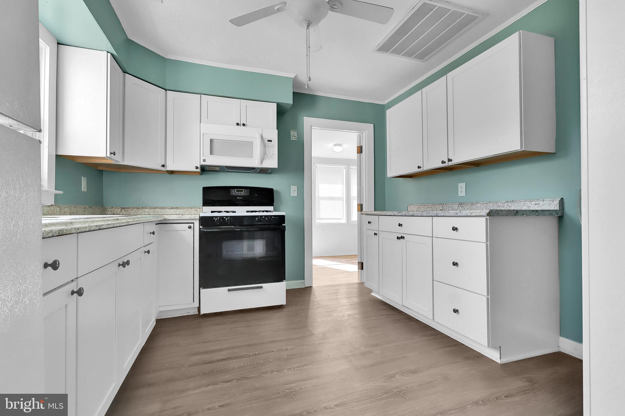 16392 Ball Point Road Piney Point, MD 20674 - Photo 8 of 25 a kitchen with white cabinets and white appliances