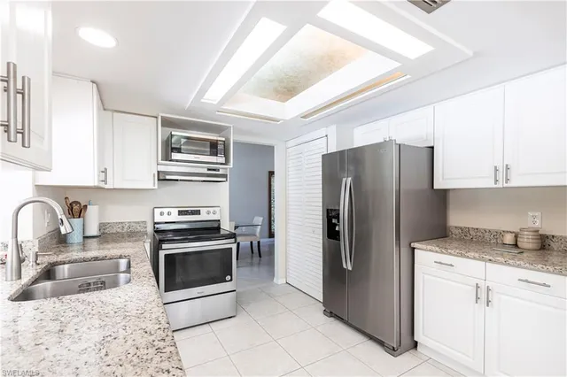 a kitchen with stainless steel appliances granite countertop a stove a sink and a refrigerator