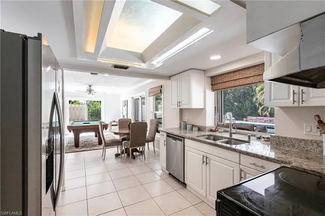a dining room with furniture and potted plants