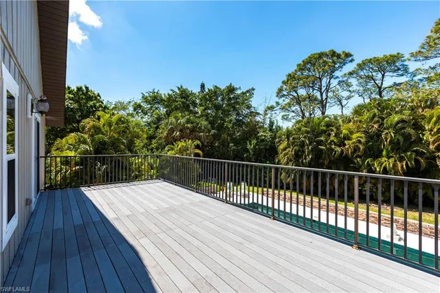 a balcony with wooden floor and fence
