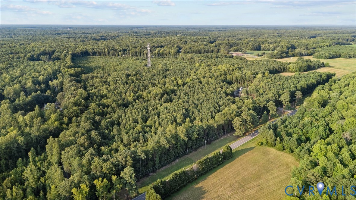 an aerial view of residential houses with outdoor space and trees