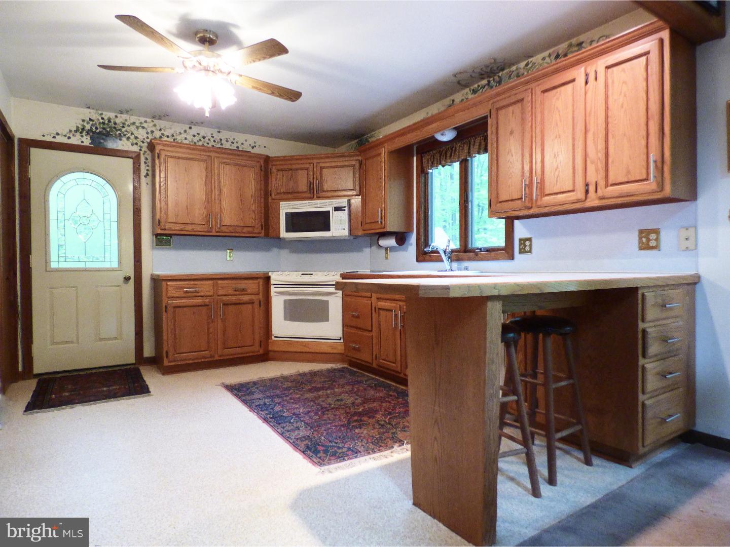 124 Alloway-Woodstown Road Alloway, NJ 08098 - Photo 19 of 25 a kitchen with stainless steel appliances granite countertop a stove top oven a sink a dining table and chairs with wooden floor
