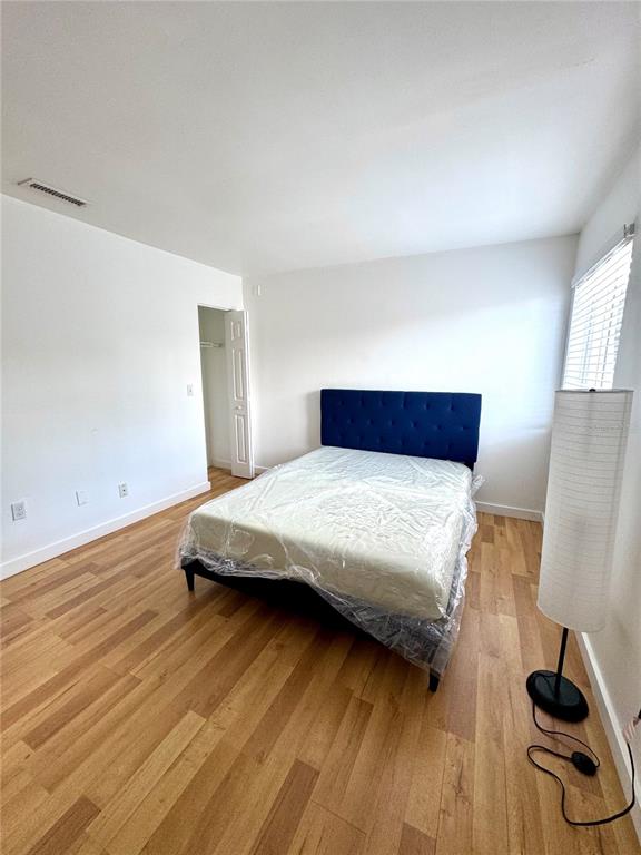 13300 Walsingham Road, Unit 11 Largo, FL 33774 - Photo 8 of 19 a bedroom with a bed and wooden floor