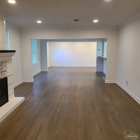 an empty room with wooden floor and fireplace
