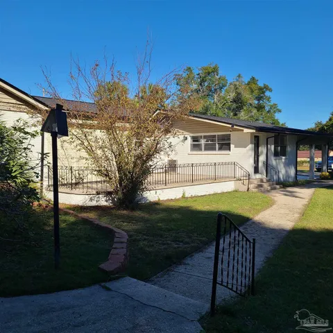 a view of backyard with large trees and wooden fence