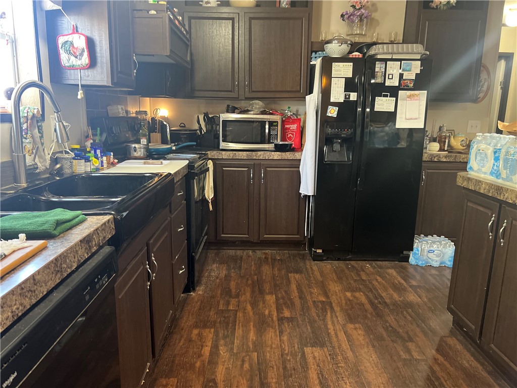 802 1st Street Bayside, TX 78340 - Photo 10 of 22 a kitchen with stainless steel appliances granite countertop a refrigerator a stove and a sink with wooden floor