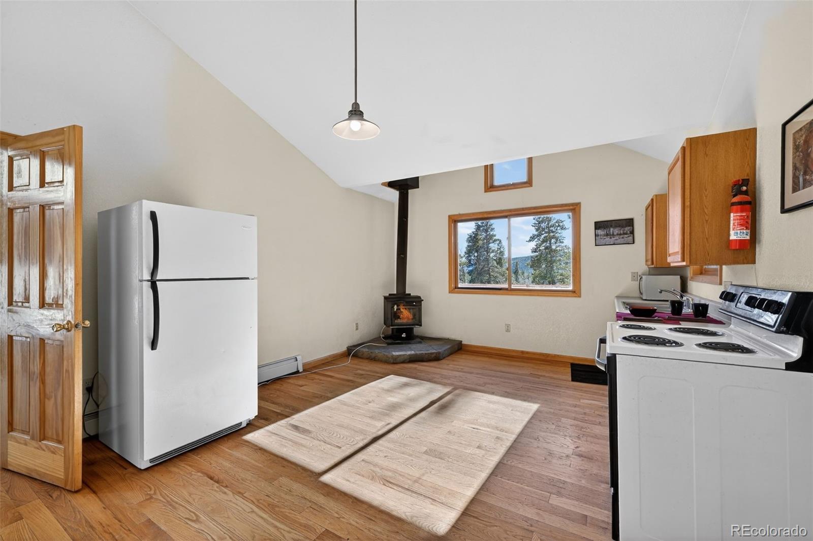 3581 Gap Road Golden, CO 80403 - Photo 19 of 45 a living room with stainless steel appliances granite countertop a refrigerator a stove a microwave oven with white cabinets and wooden floor