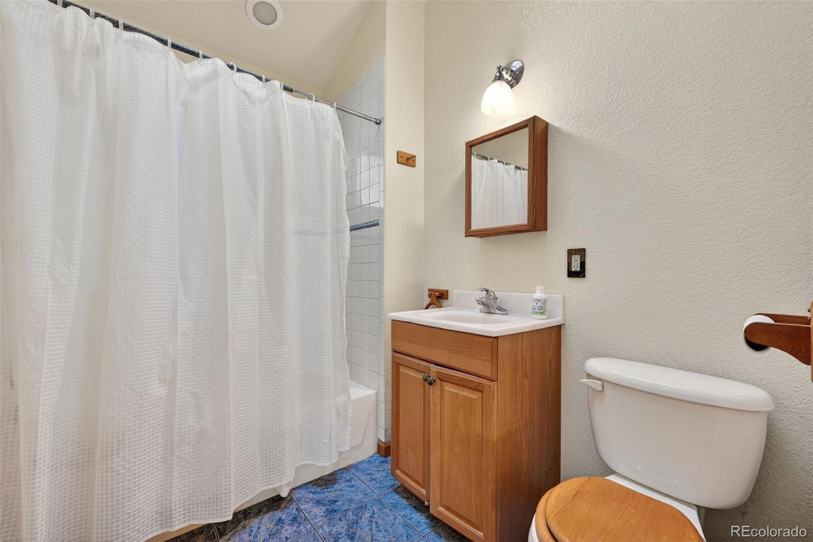 3581 Gap Road Golden, CO 80403 - Photo 22 of 45 a bathroom with a toilet sink vanity and mirror