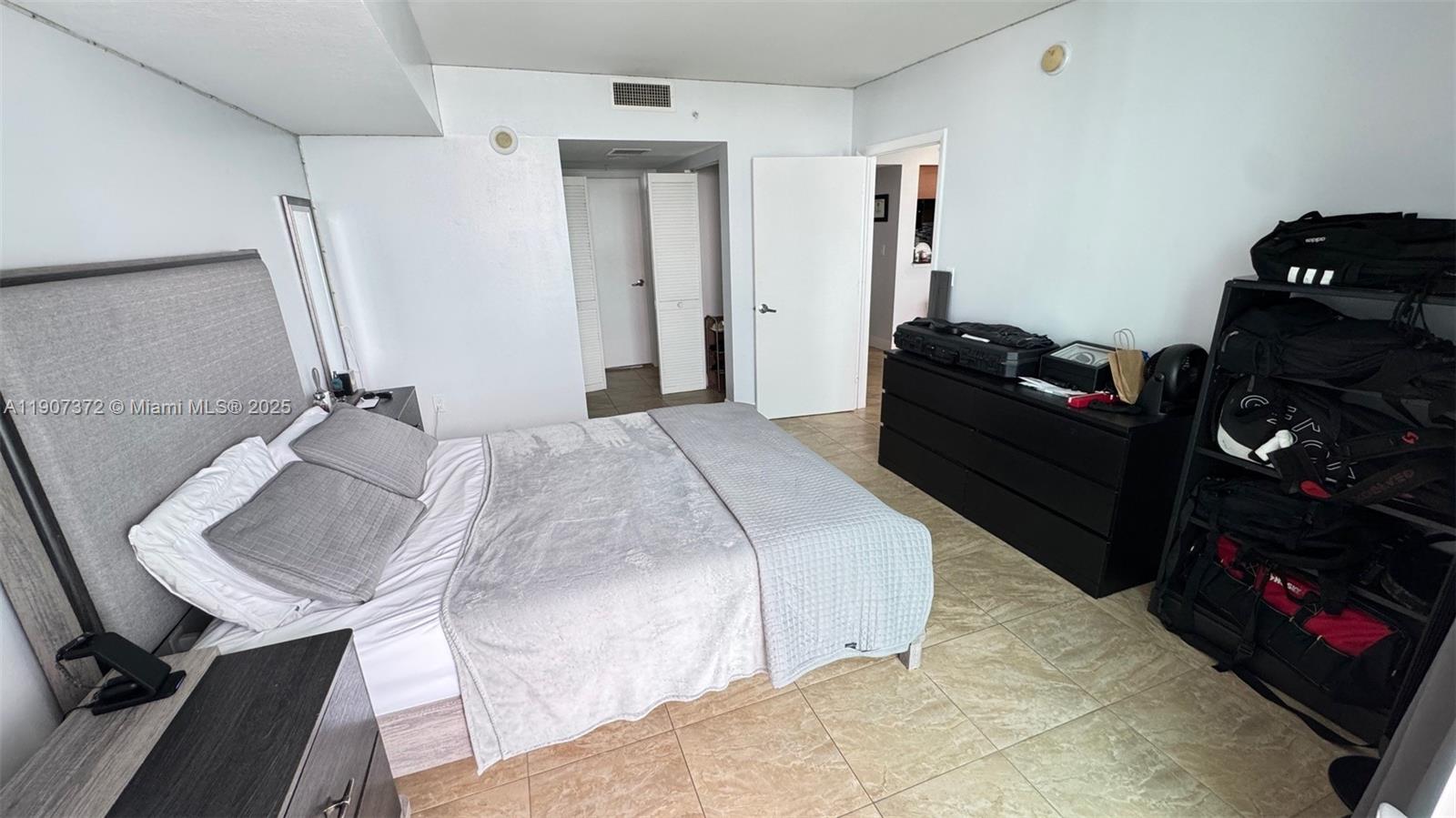 1800 North Bayshore Drive, Unit 1906 Miami, FL 33132 - Photo 15 of 21 a bedroom with a bed and a mirror
