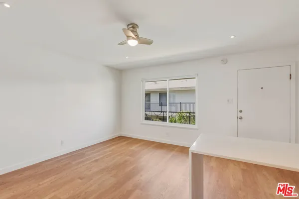 a kitchen with stainless steel appliances granite countertop a stove a sink and white cabinets with wooden floor