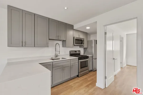 a kitchen with cabinets stainless steel appliances and a sink