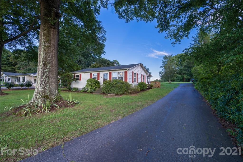 a view of an house with backyard and a tree