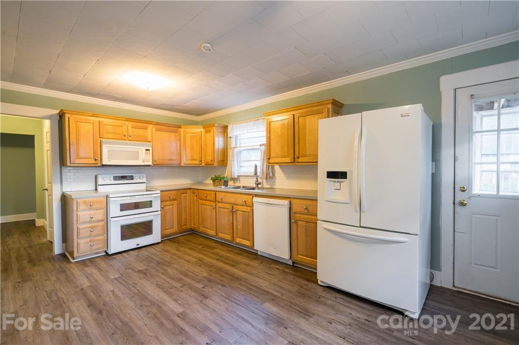 2289 Claremont Road Newton, NC 28658 - Photo 11 of 20 a kitchen with white cabinets and white appliances