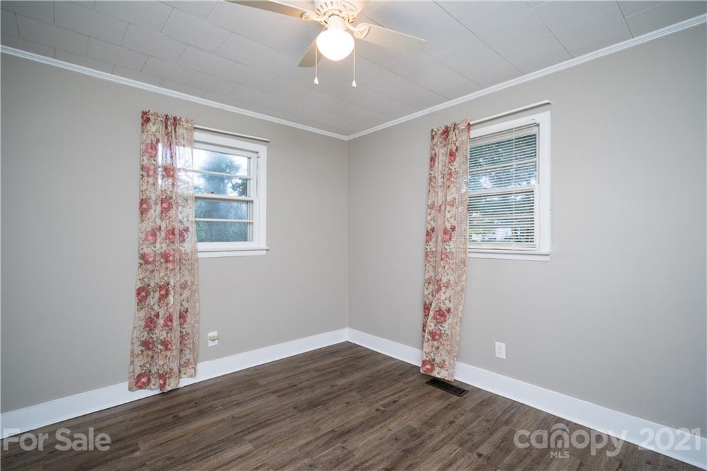 2289 Claremont Road Newton, NC 28658 - Photo 18 of 20 a view of an empty room with window wooden floor and a chandelier fan