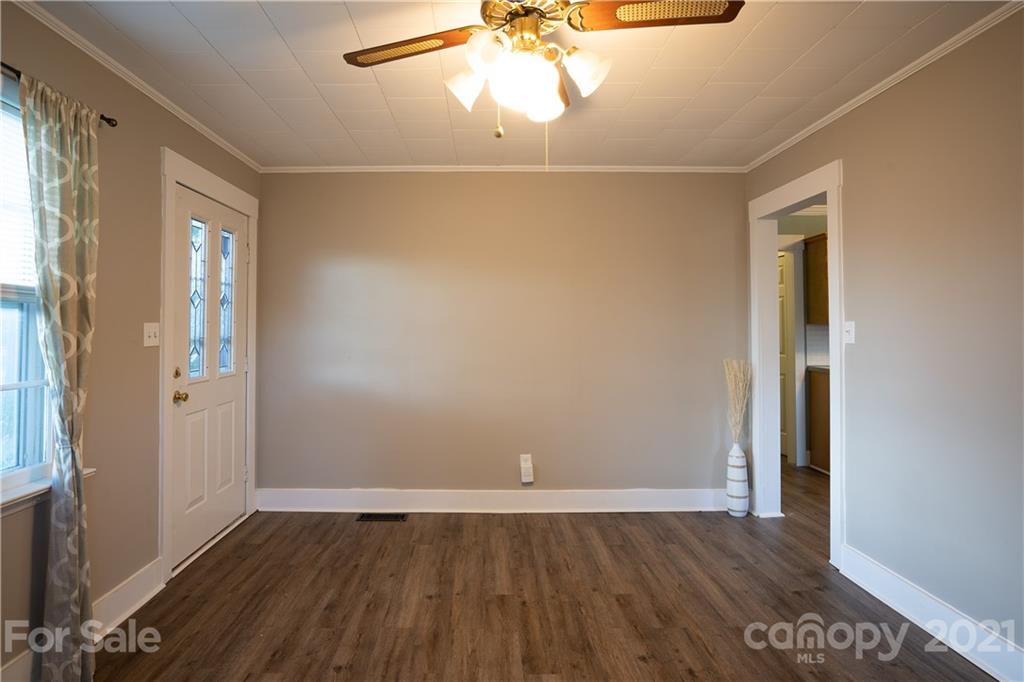 2289 Claremont Road Newton, NC 28658 - Photo 9 of 20 an empty room with wooden floor cabinet and windows