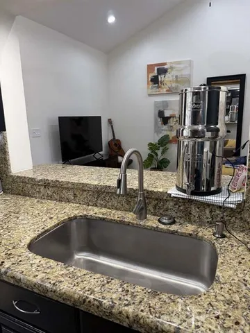 a bathroom with a granite countertop sink and a mirror