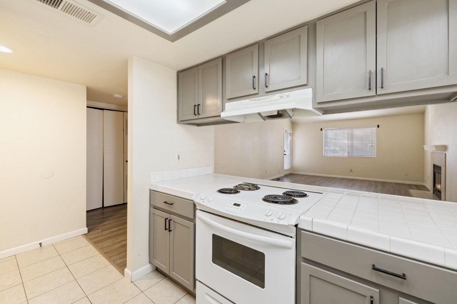 7675 North First Street, Unit 136 Fresno, CA 93720 - Photo 11 of 42 a kitchen with granite countertop white cabinets and white appliances