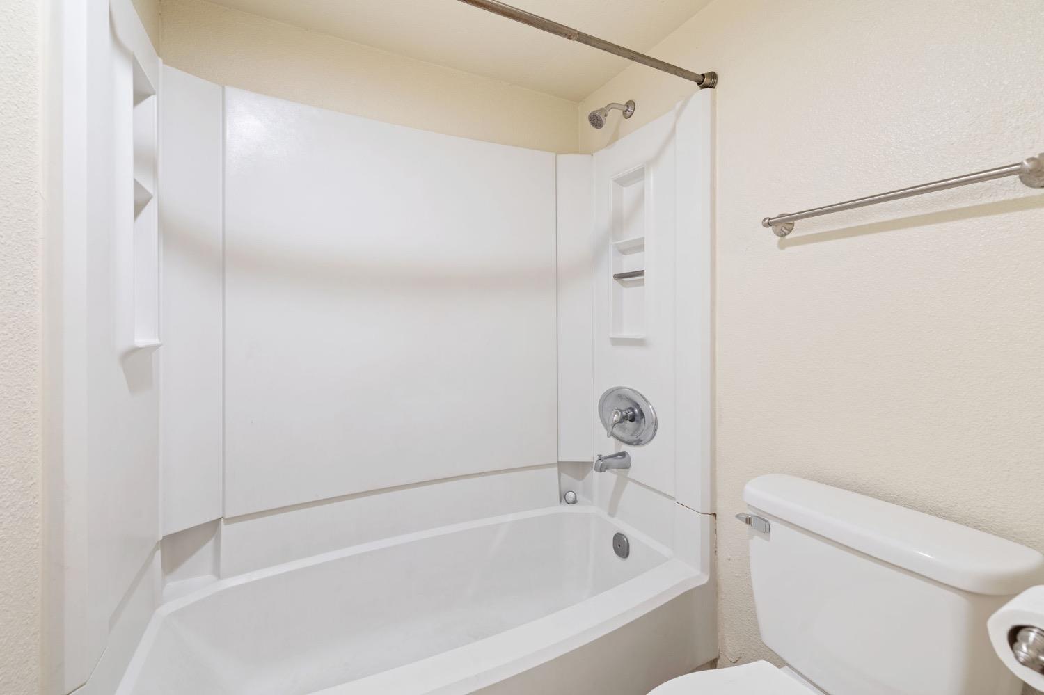 7675 North First Street, Unit 136 Fresno, CA 93720 - Photo 18 of 42 a bathroom with a bathtub and a toilet