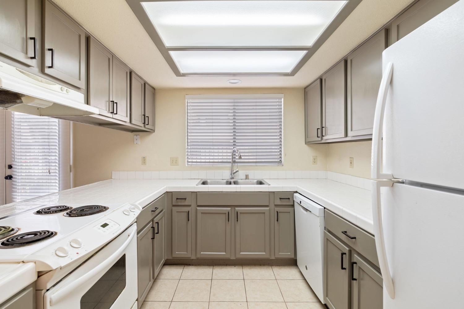 7675 North First Street, Unit 136 Fresno, CA 93720 - Photo 2 of 42 a kitchen with a sink stove top oven and cabinets