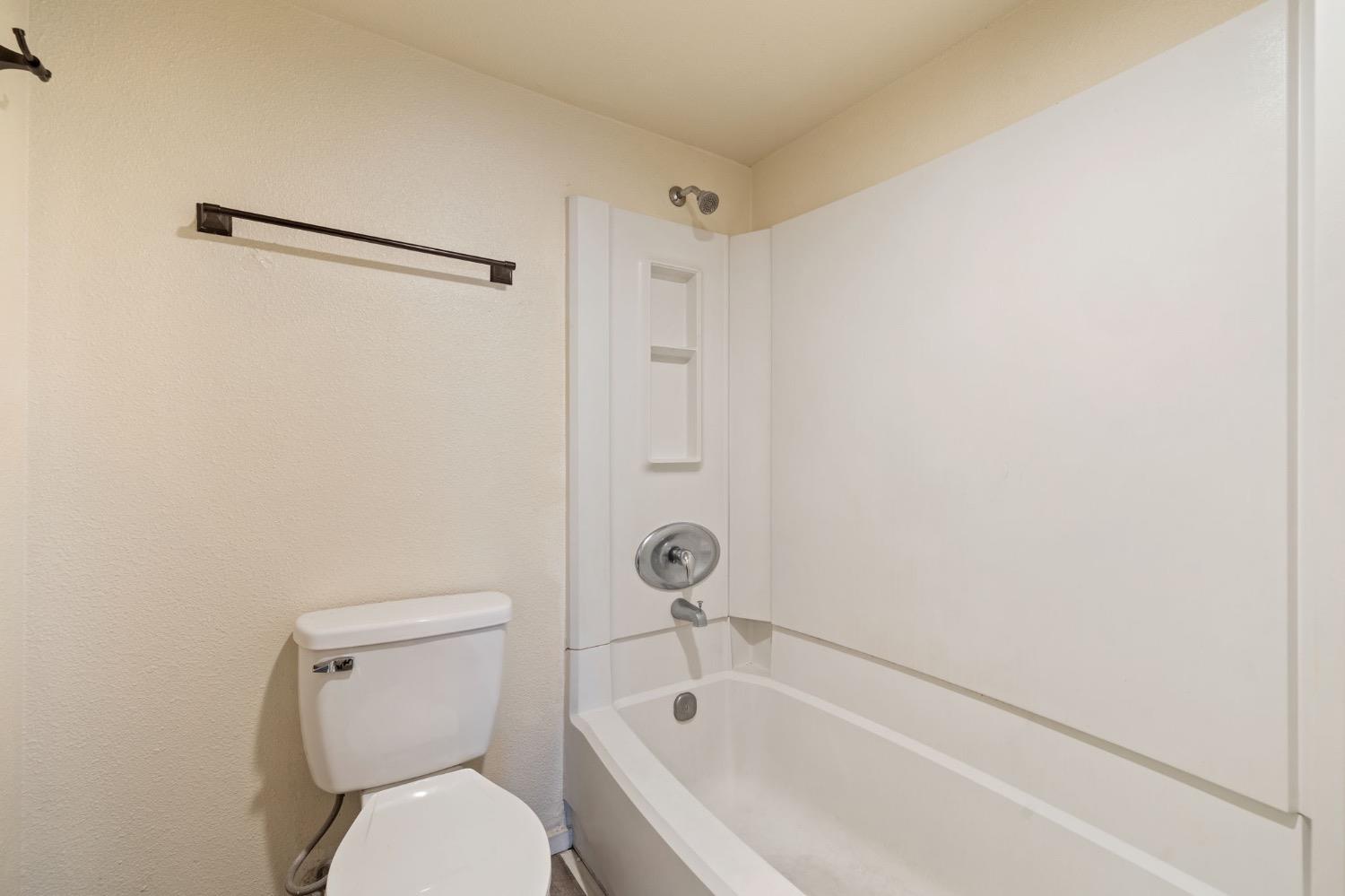 7675 North First Street, Unit 136 Fresno, CA 93720 - Photo 22 of 42 a bathroom with a toilet and a bathtub