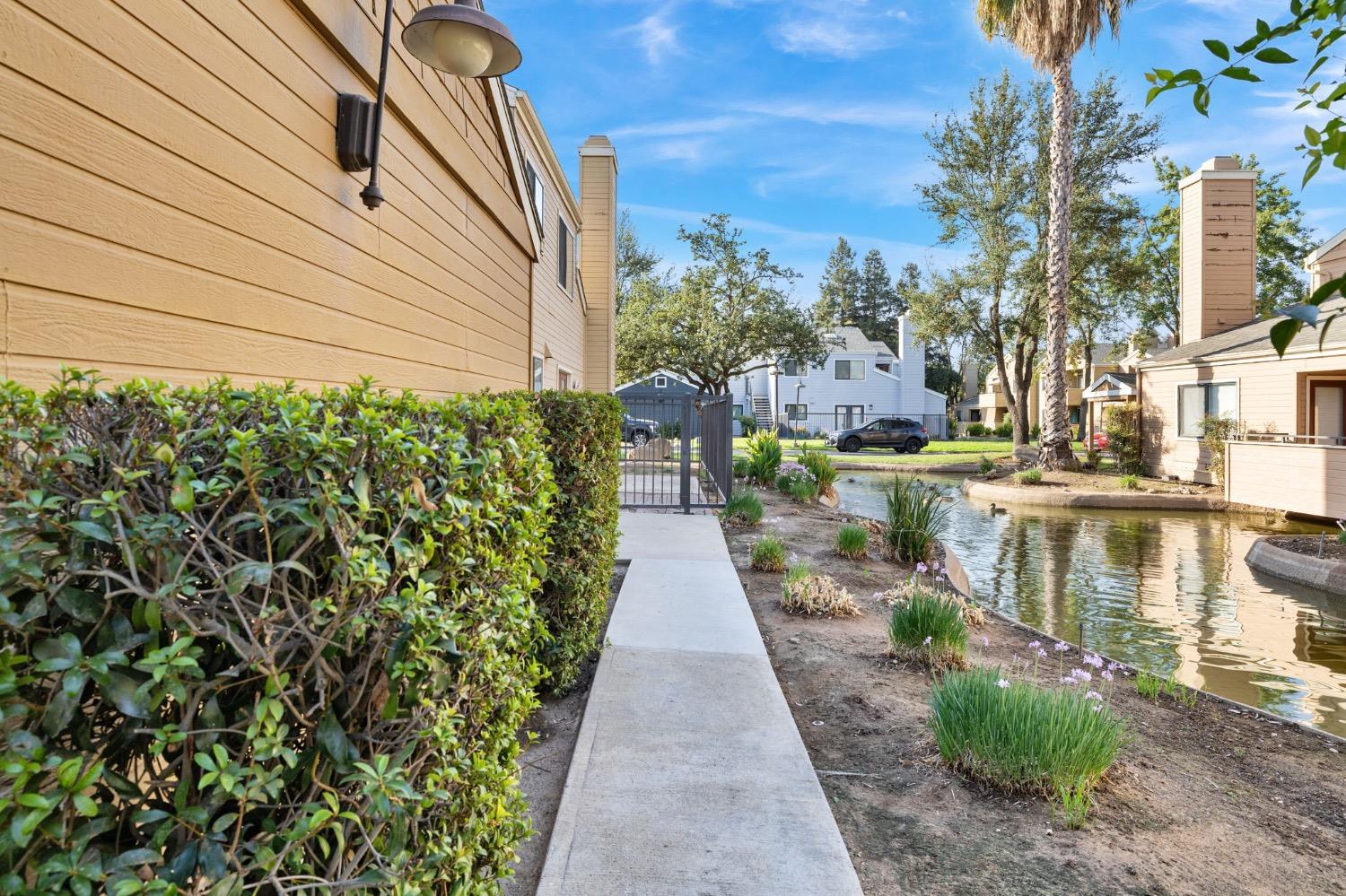 7675 North First Street, Unit 136 Fresno, CA 93720 - Photo 6 of 42 a view of a patio with table and chairs next to a yard
