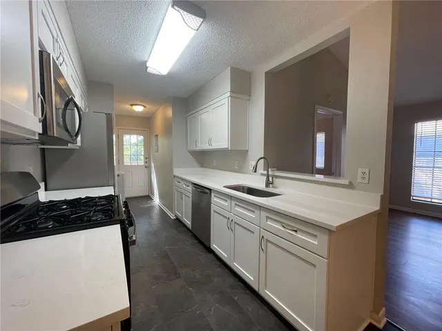 a kitchen with stainless steel appliances granite countertop a sink stove and cabinets