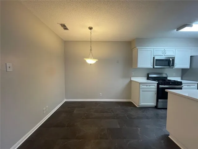 a kitchen with a sink a stove top oven and white kitchen