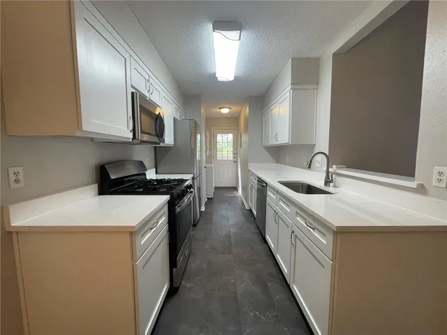 a kitchen with a sink stove and cabinets