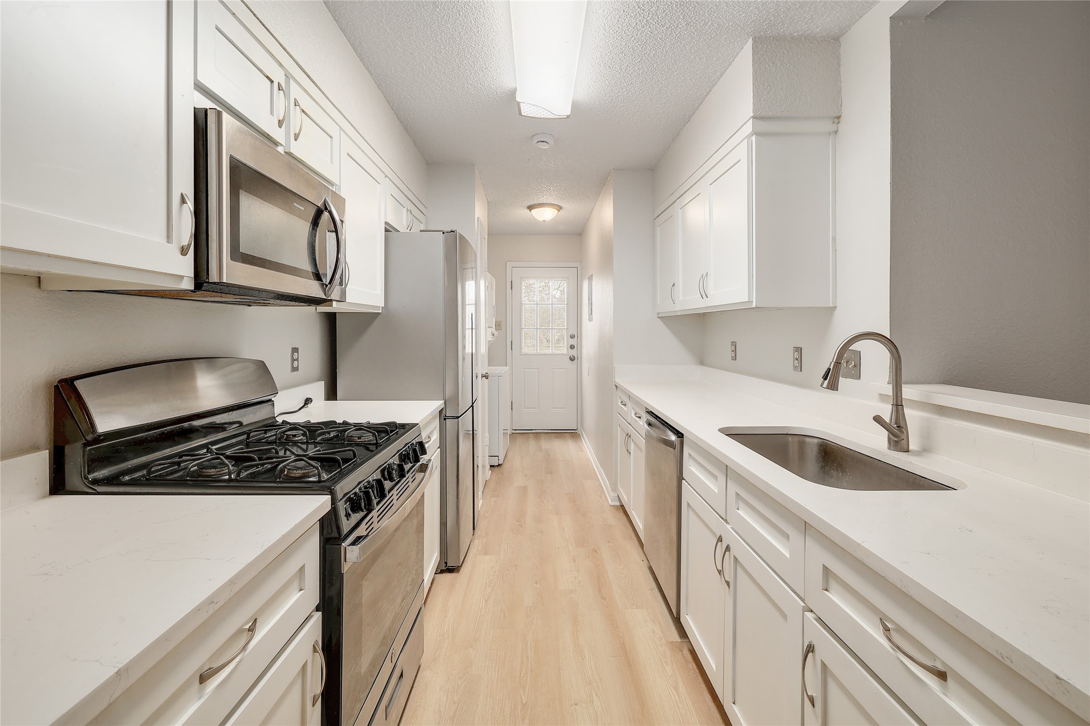 1915 Margalene Way Austin, TX 78728 - Photo 14 of 23 a kitchen with stainless steel appliances a sink stove and cabinets