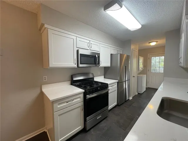 a kitchen with a sink stove and refrigerator