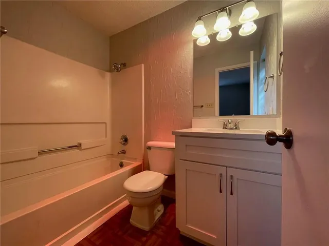 a bathroom with a sink a toilet and a mirror