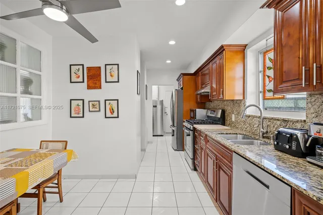 a kitchen with stainless steel appliances granite countertop a refrigerator and a stove top oven