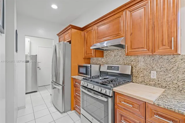 a kitchen with stainless steel appliances wooden cabinets and a stove top oven
