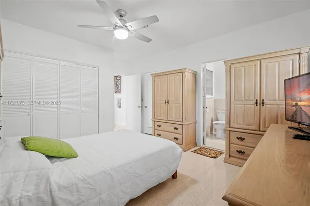 a bedroom with a bed a dresser and a chandelier