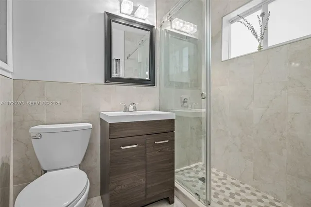 a bathroom with a toilet a sink and mirror