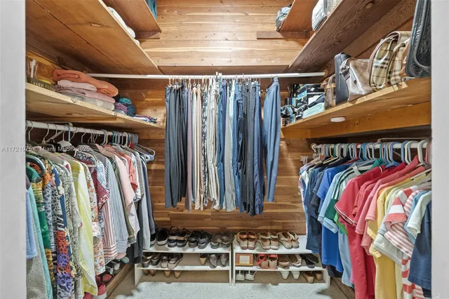 a view of walk in closet with clothes and shoes