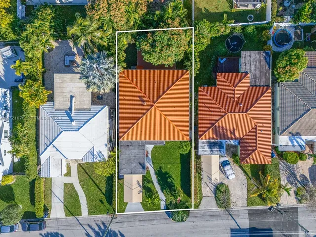 an aerial view of a city with lots of residential buildings ocean and mountain view in back