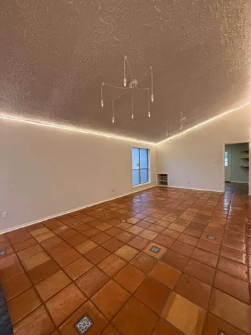 a view of an empty room with window and fire place