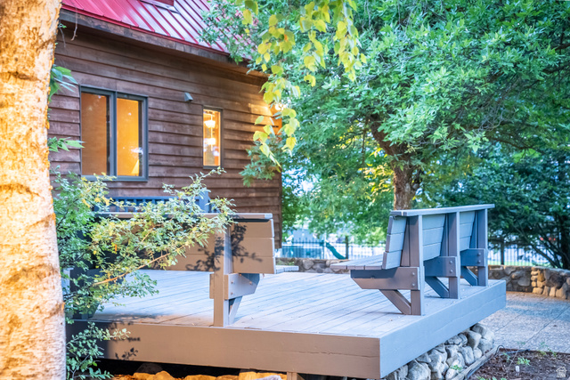 435 Canyon Road Millville, UT 84326 - Photo 55 of 113 Outdoor deck area featuring built-in seating, a stone retaining wall, and mature landscaping