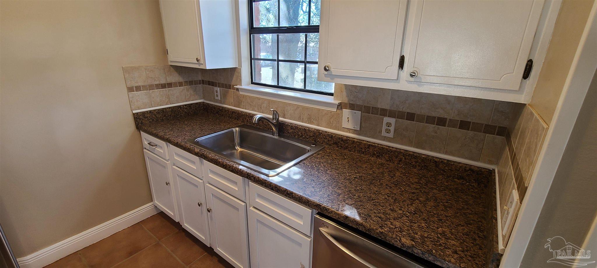 7250 Hilburn Road, Unit 4D Pensacola, FL 32504 - Photo 3 of 10 a kitchen with granite countertop a sink and a stove