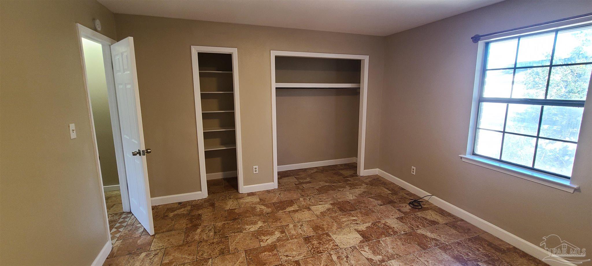 7250 Hilburn Road, Unit 4D Pensacola, FL 32504 - Photo 8 of 10 an empty room with closet and windows