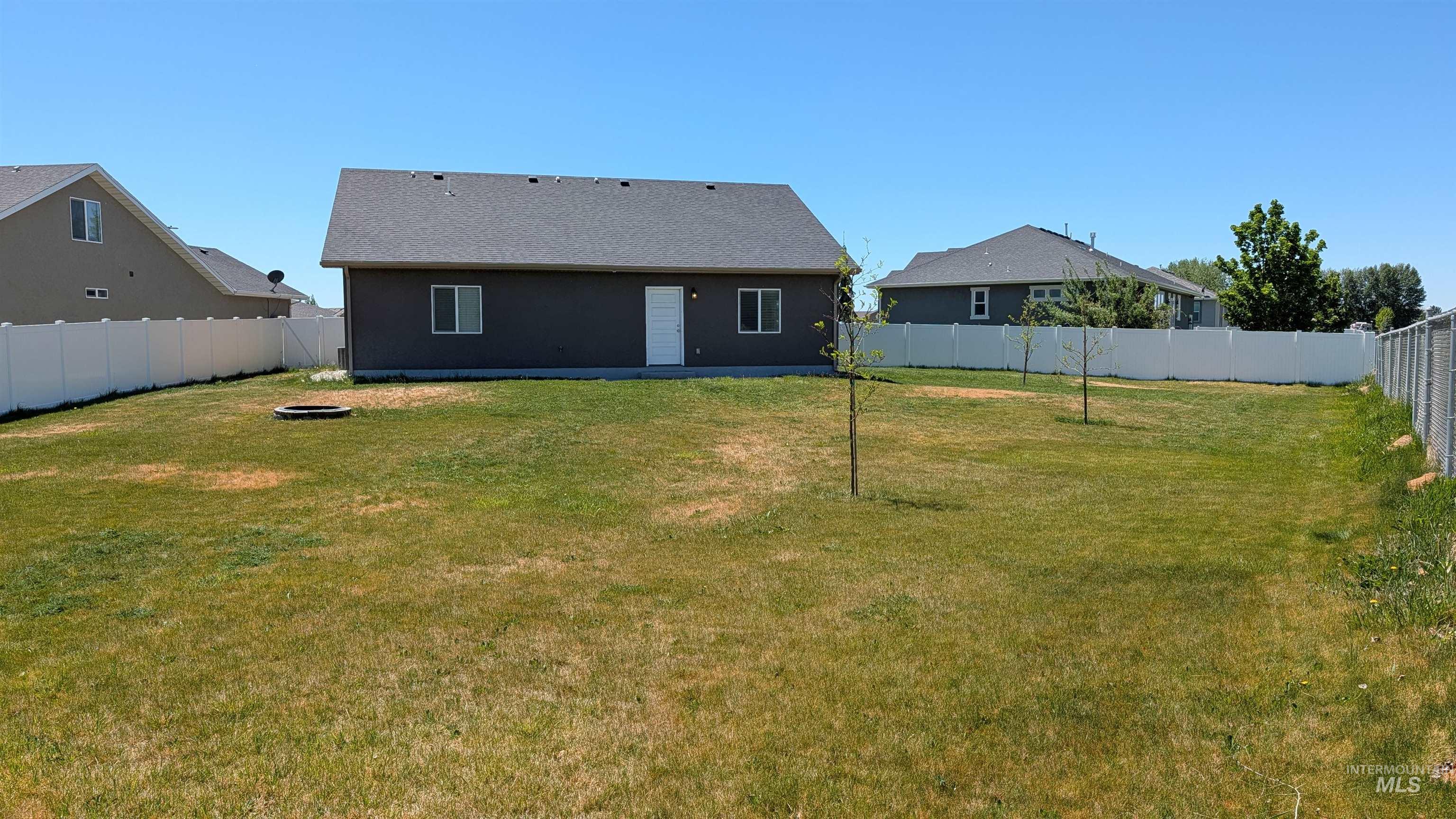 622 Lochsa Loop Heyburn, ID 83336 - Photo 17 of 17 Expansive backyard featuring a manicured lawn, full vinyl privacy fencing, and two young trees